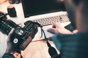 Person using camera and laptop for a shoot.