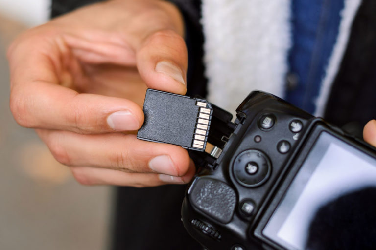 A photographer loading a memory card into a camera