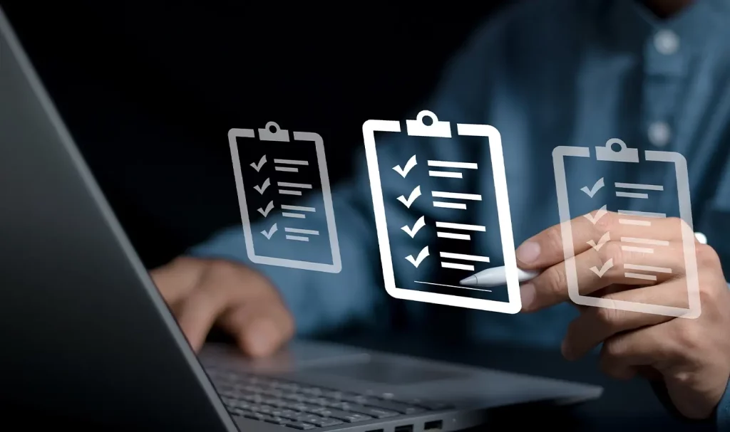 A man's torso in a blue button-down shirt sits in front of an open gray laptop, with a white stylist in the left hand and three clipboard and checklist clipart graphics in the foreground.