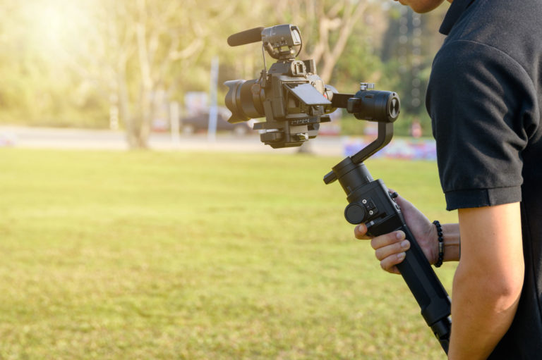 Videographer holding camera attached to gimbal