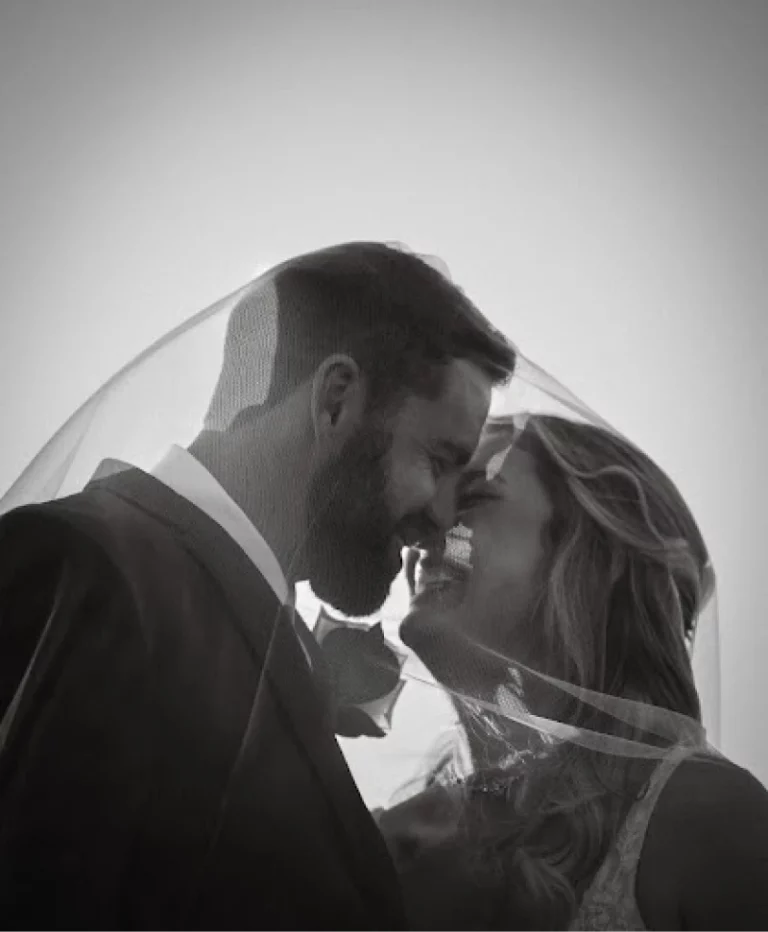 bride and groom in black and white photograph under veil