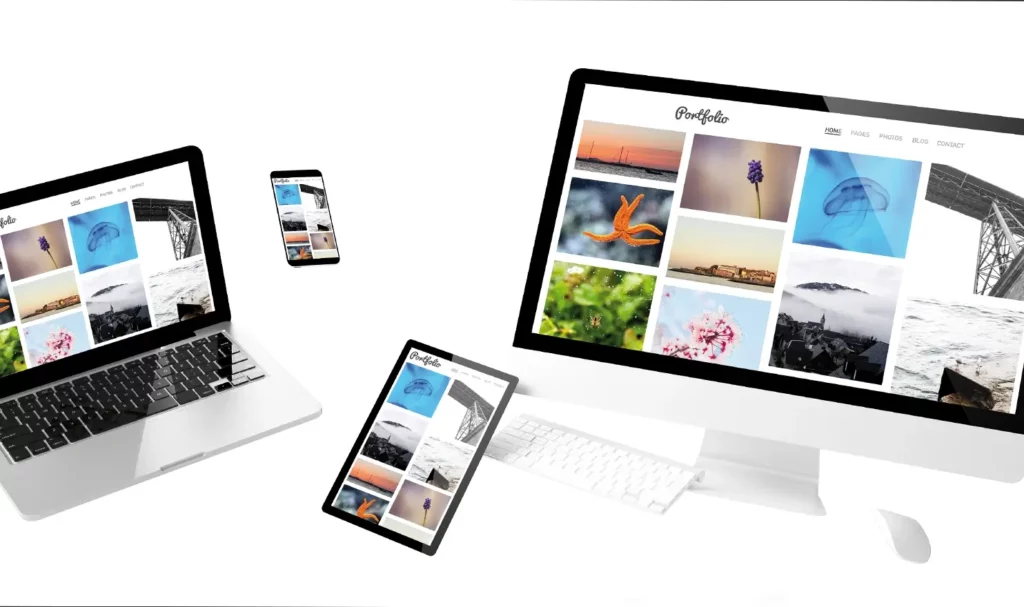 A white monitor, laptop, tablet, and smartphone on a while background with the same photo portfolio website on each screen.