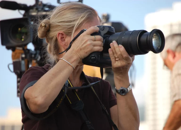 A female photojournalist capturing a critical moment for her photo story.