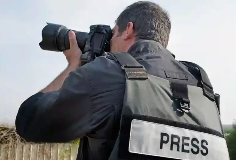 Press photographer in the middle of a shoot outdoors