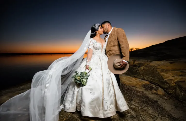 Newlyweds sharing a kiss outdoors.