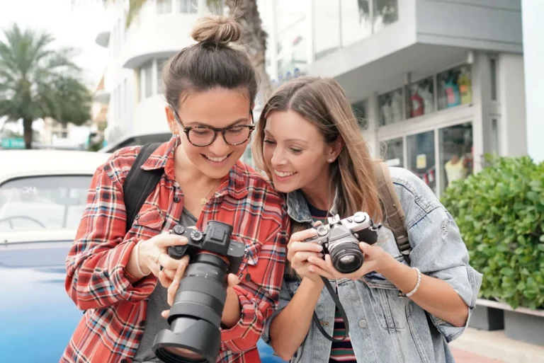 Two photographers looking at each other's photos.