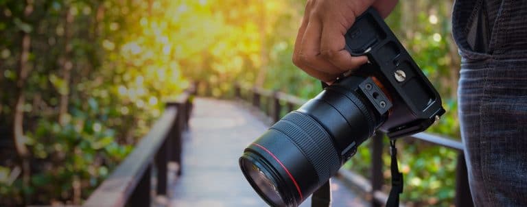 photographer walking on a bridge