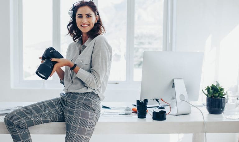 Photographer with camera sitting on desk